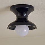 Close view of the navy spool ceiling light with a round opal globe
