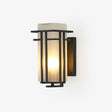 Black frame lantern outdoor wall light, open iron bars around a white glass box, lit