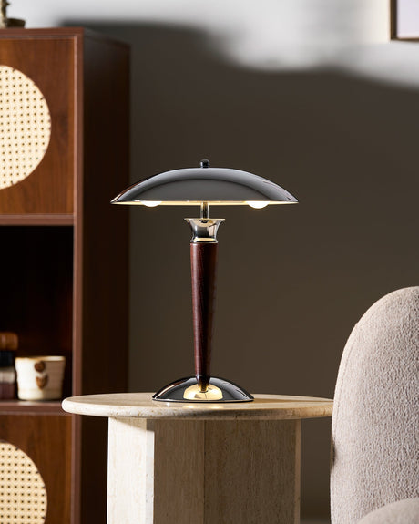 Chrome dome table lamp on a side table in front of a cane panel