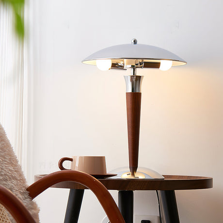 Chrome dome table lamp on a round table beside a wooden chair