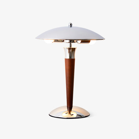 Mid century modern table lamp with a chrome dome and a walnut stem on a plain background