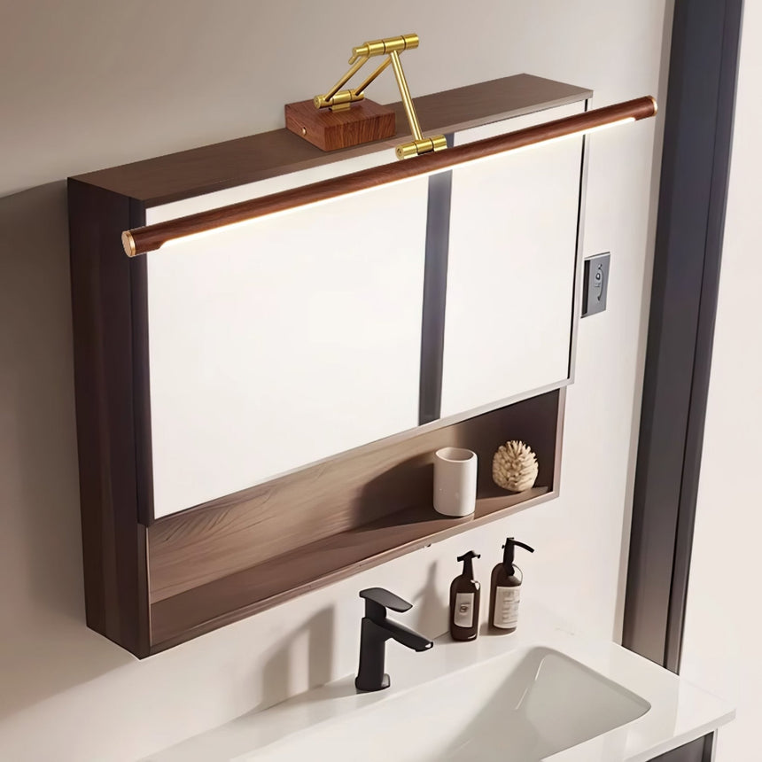 Bar lit above a walnut mirror cabinet over a basin with a black tap