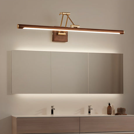 Long bar lit above a wide mirror over a walnut vanity with folded towels