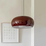 Red glass dome lit beside a framed print on a pale wall