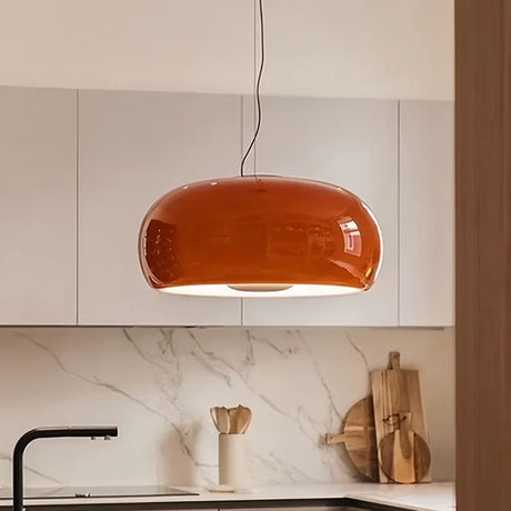Red glass dome pendant above a marble kitchen counter