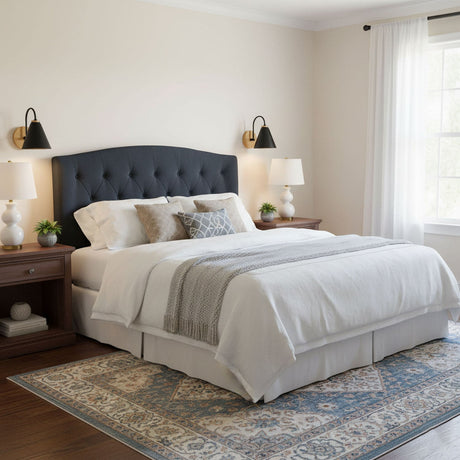 Two sconces lit above a bed with a tufted headboard and two nightstands