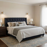 Two sconces lit either side of a bed with a dark headboard and side tables