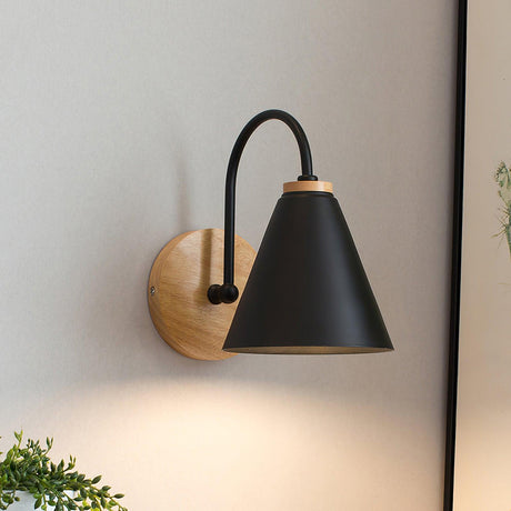 Black iron cone lit on a curved stem rising from a round wood backplate