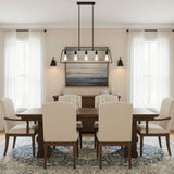 Sconces lit on a dining room wall beside a table, chairs and a window