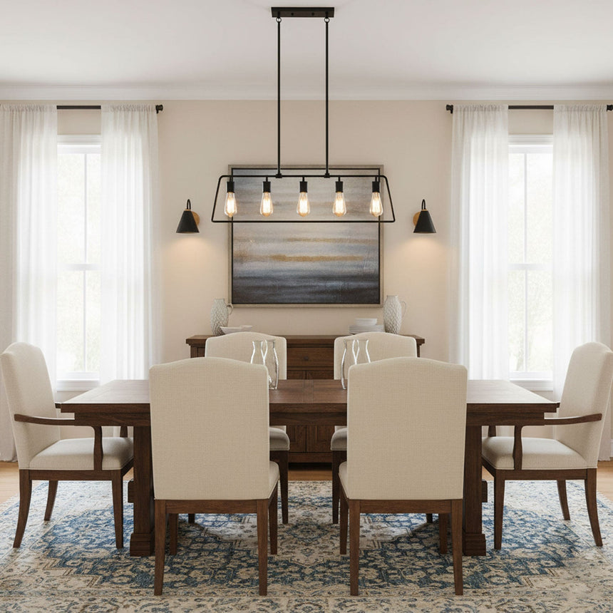 Sconces lit on a dining room wall beside a table, chairs and a window