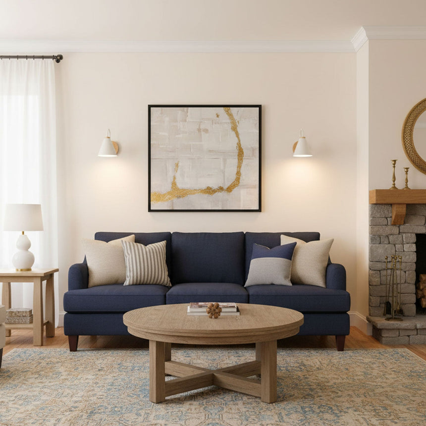 Sconces lit above a blue sofa beside a framed map and a round table