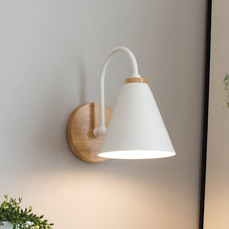 White iron cone lit on a curved stem rising from a round wood backplate