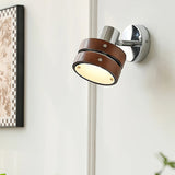 Sconce lit beside a framed print and a window with light coming through