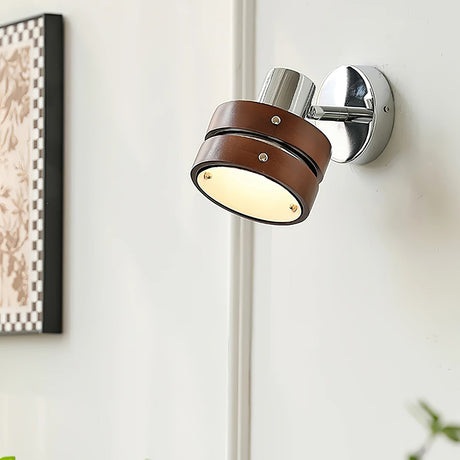 Sconce lit beside a framed print and a window with light coming through