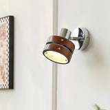 Sconce lit beside a framed print on a pale wall in a quiet corner
