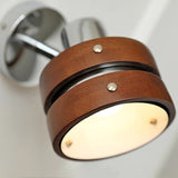 The frosted lens lit warm under the walnut drum head, seen close