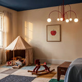 The red version in a child room with a canvas tent, rocking horse and framed print