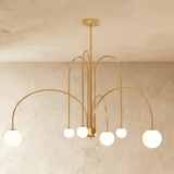 The gold frame turned so the arched arms cross above the lit globes