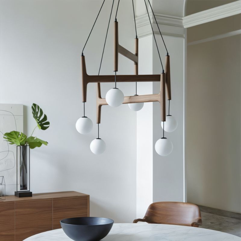 The walnut version lit over a round table with a bowl, a chair and a wood sideboard