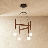 Four milk glass globes hanging from crossed walnut bars on thin cables