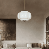 White ribbed shade lit in a warm lounge above a low sofa and cushions