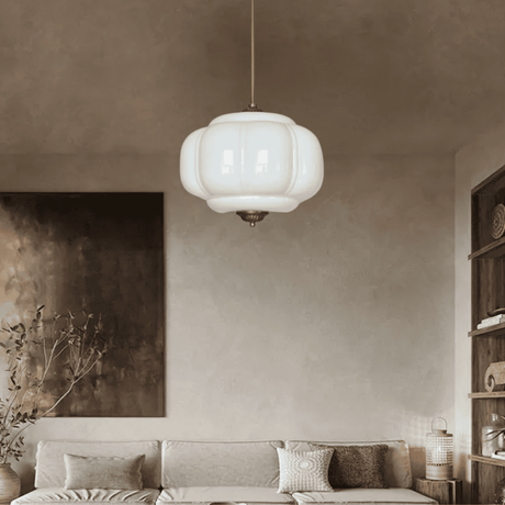 White ribbed shade lit in a warm lounge above a low sofa and cushions