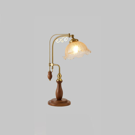 Amber crackle glass shade lit on the brass arch against a gray ground