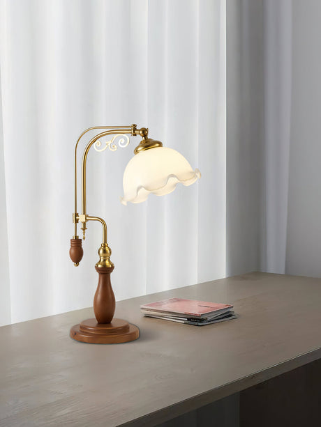 Brass arch lamp lit on a gray surface in front of a white curtain