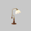 Brass arch lamp with a milky white ruffled glass shade, unlit