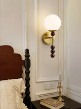 Milk glass globe lit beside a spindle bed with a book on the table