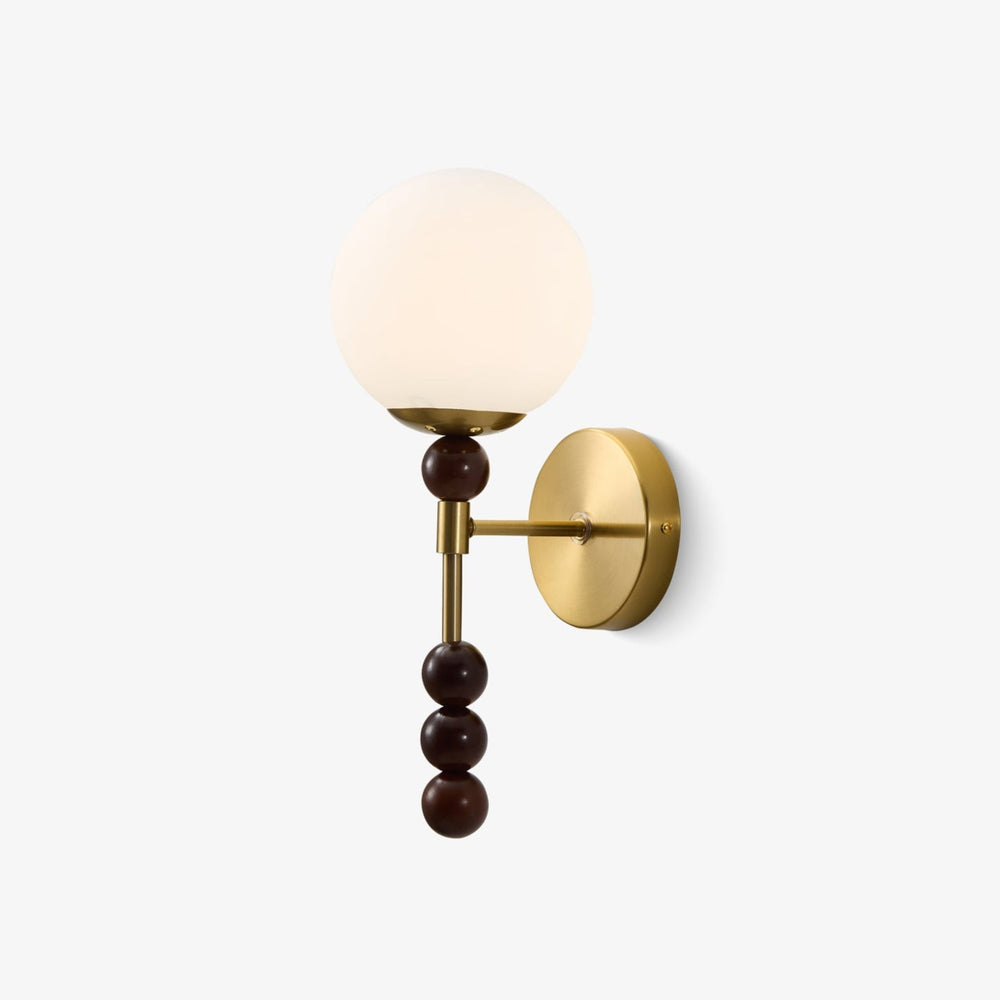 Milk glass wall sconce with a globe shade above three walnut beads