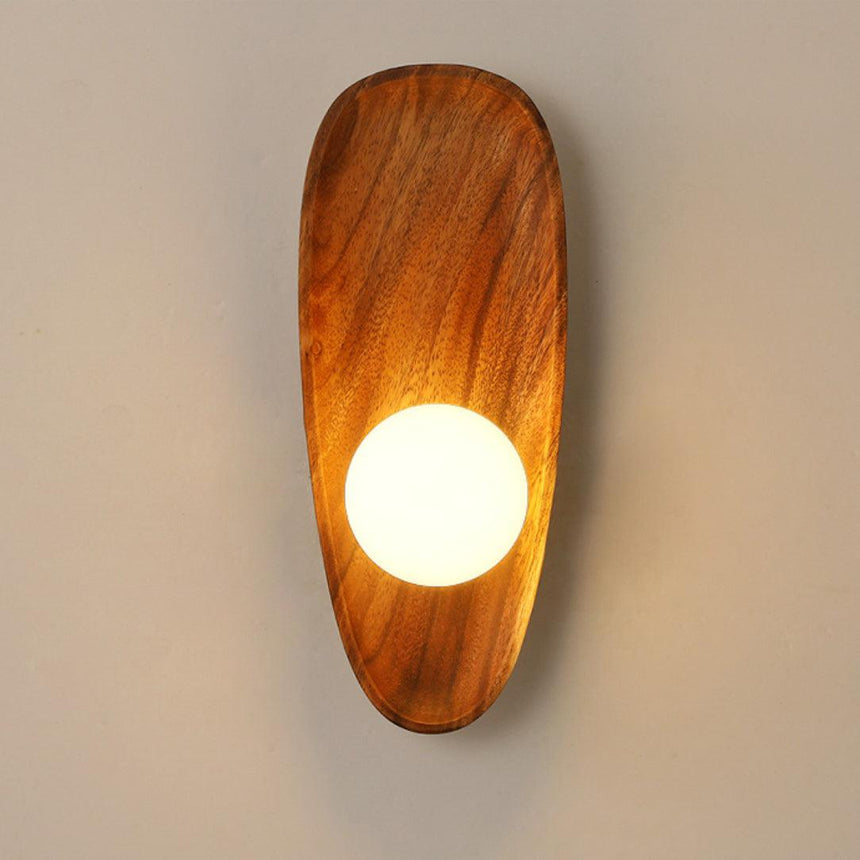 The tall walnut pebble lit warm with the milk glass globe glowing below