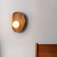 The wide walnut pebble lit, the milk glass globe glowing at its lower edge