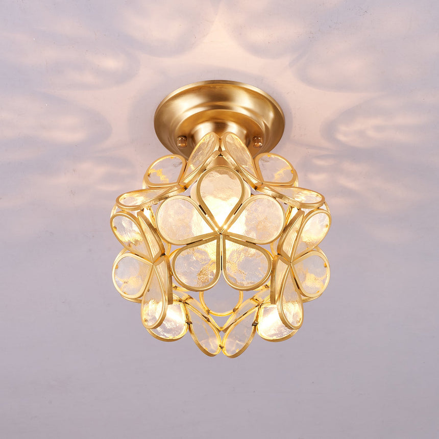 Clear glass petal ceiling light lit against a pale ceiling