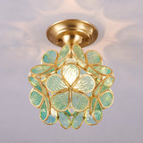 Green glass petal ceiling light lit on a plain ceiling