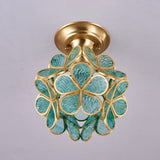 Green glass petal ceiling light seen close with the petals lit
