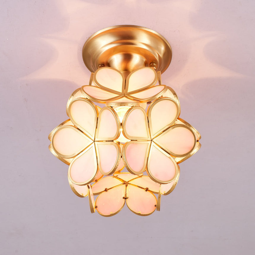 Pink glass petal ceiling light lit against a pale ceiling