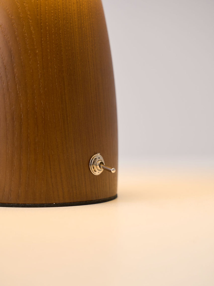 Close view of the turned walnut base and the small switch on its side