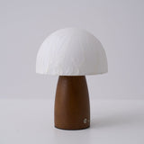 Mini table lamp lit on a bedside chest in a warm room at night