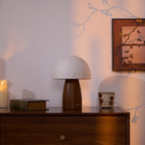 Mini table lamp lit on a chest in the corner of a quiet room