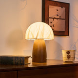 Mini table lamp lit beside a candle holder and a stack of books