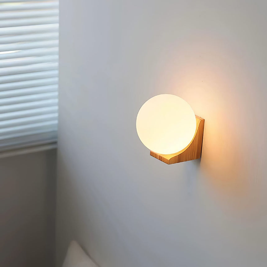 Sconce lit on a wall corner beside a window with a drawn white blind