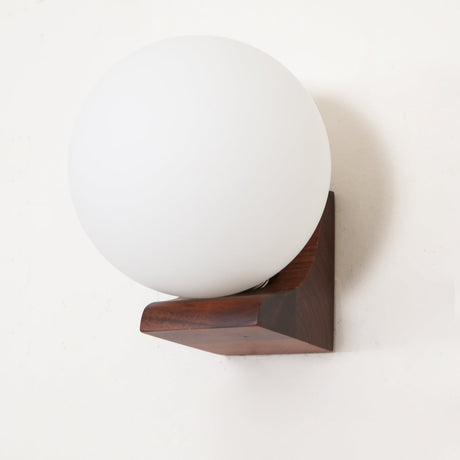 Close view of the glass sphere where it meets the folded wood bracket