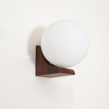 The walnut bracket holding the white glass sphere, seen from the front