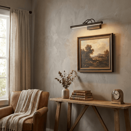 Gold bar lit above a framed picture on a plaster wall beside a wood table