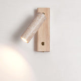 Travertine tube lit on a light wood plate with the button switch below