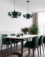 Green layered shades above a dining table in a pale room