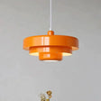 Layered metal shade in orange on a plain background