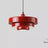 Layered metal shade in red on a plain background
