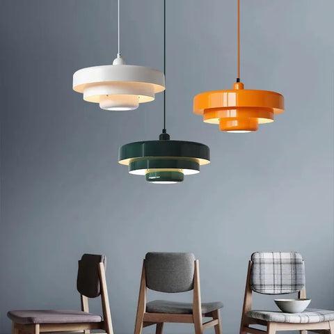 Three layered metal shades in white, green and orange over a table